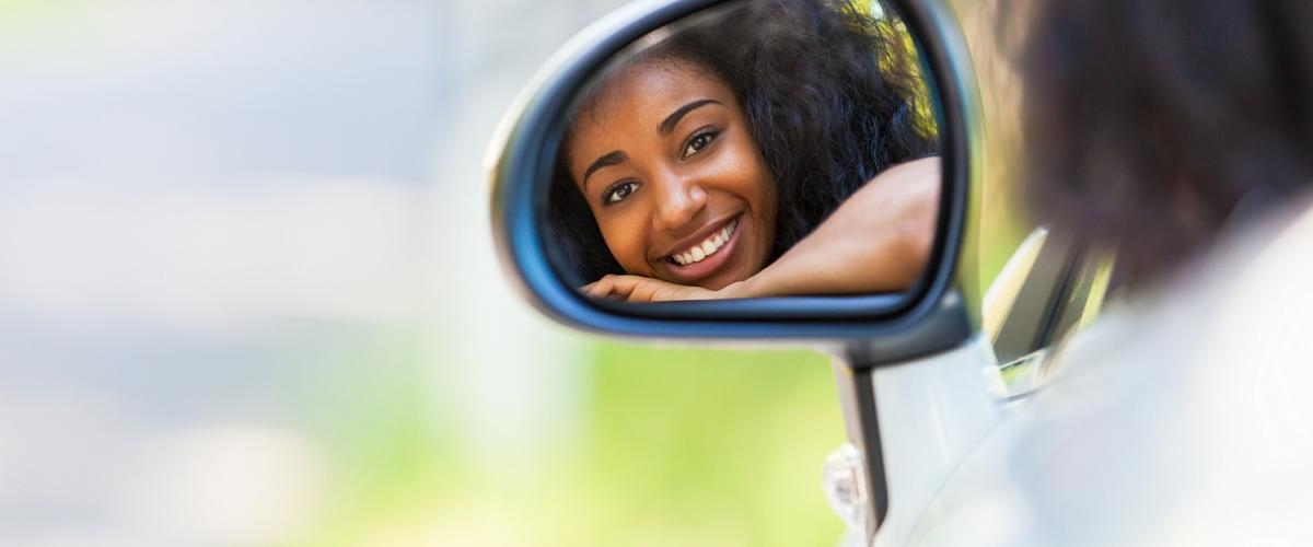 Teen driver looking in rearview mirrror