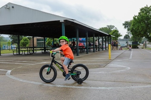 Image of a young child riding a bike while wearing a helmet