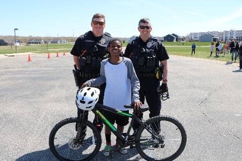 Image of two police officers and a child with a bike