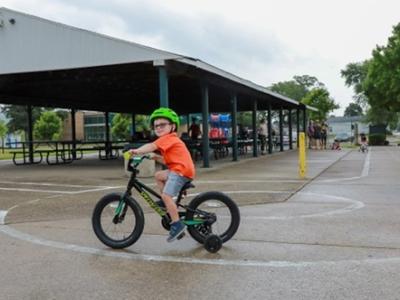 Image of a young child riding a bike while wearing a helmet